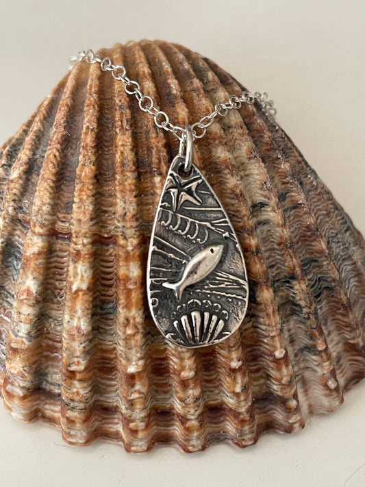 Small silver under the sea necklace on shell