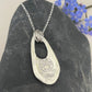 The reverse of the forget-me-not flower pendant showing the molly and me jewellery  paw print together with the 999 mark for fine silver on the pendant with a cutout and 3 jump rings attaching it to a silver chain. 