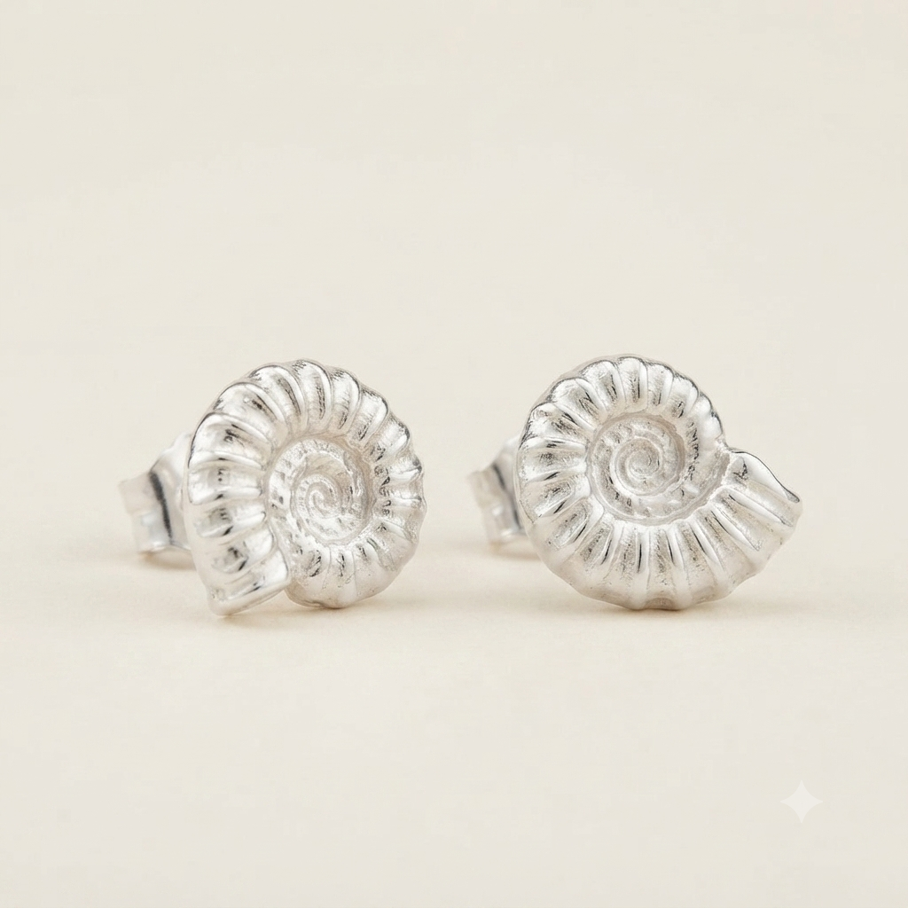 Silver ammonite spiral fossil shell stud earrings on a white background