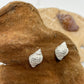 Silver whelk shell earrings on a dark sand colour with a real whelk shell in the background