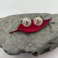Textured disc shaped stud earrings with tiny smooth hearts set on a red leaf for love 