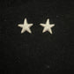 Small detailed silver starfish stud earrings on a black background